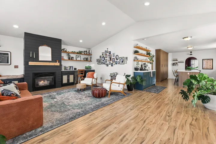 Vaulted ceiling, wood-finish flooring, built-in fireplace, recessed lighting, and integrated shelving