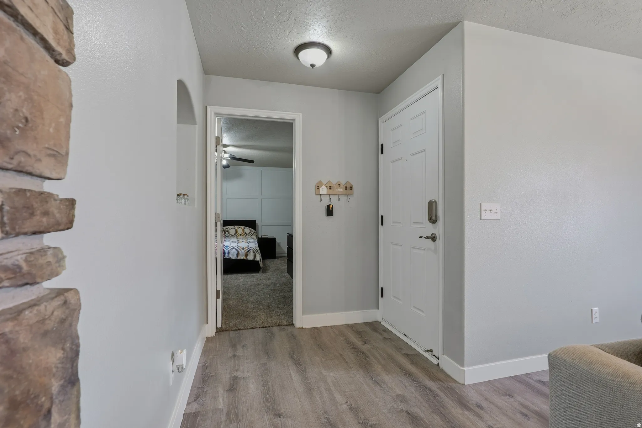 Entryway featuring wood-finish flooring and a stone-clad architectural element