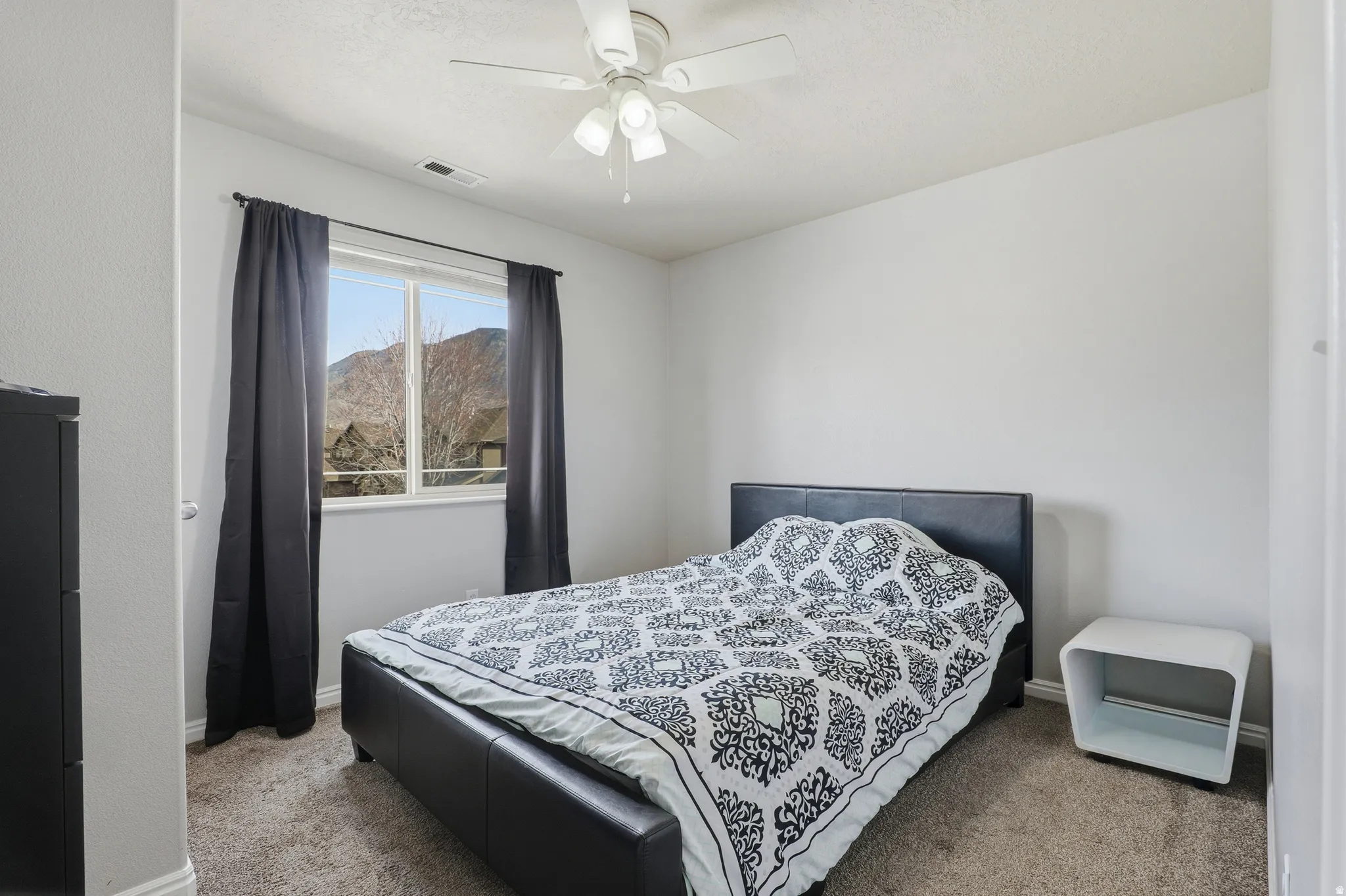 Wall-to-wall carpeting and a ceiling fan with integrated lighting