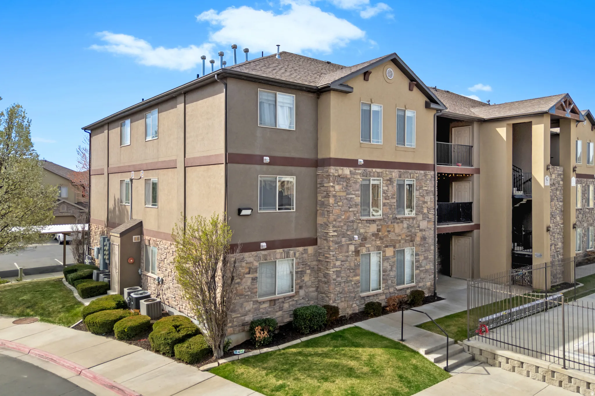 Multi-story stucco exterior with stone veneer accents