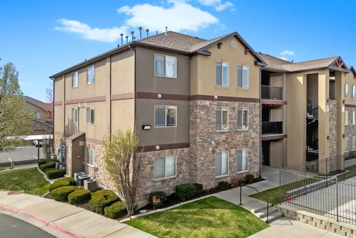 Multi-story stucco exterior with stone veneer accents
