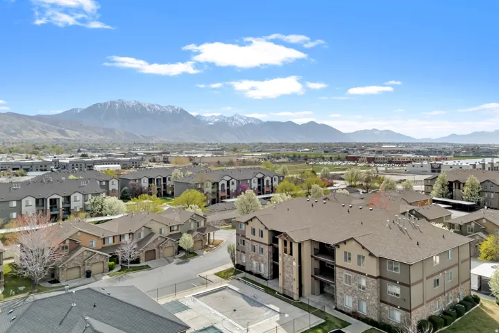 Community featuring multi-story residential buildings, townhomes, and a central swimming pool