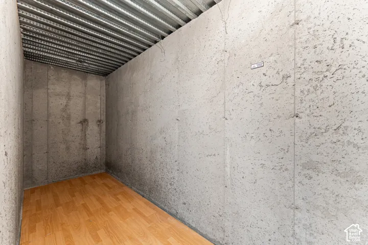 Concrete walls with exposed metal ceiling and wood-finish flooring