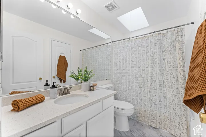 Vanity with integrated sink, stone-finish countertop, and brushed nickel faucet