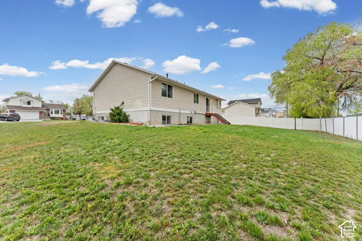Expansive sloped lawn with a vinyl privacy fence