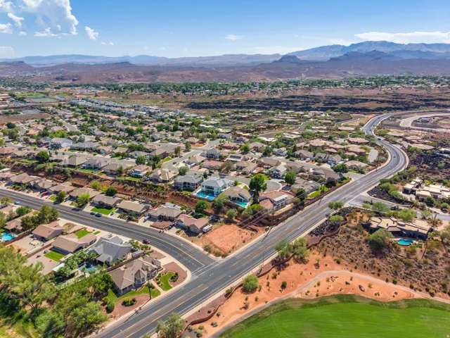 Expansive neighborhood with diverse architectural styles, visible residential streets, and distant mountain ranges