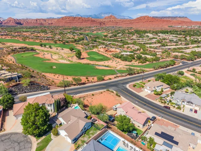 Expansive desert golf course setting with red rock formations