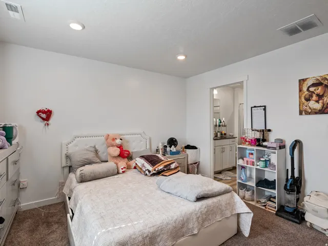Recessed ceiling lighting, white walls, and carpet flooring