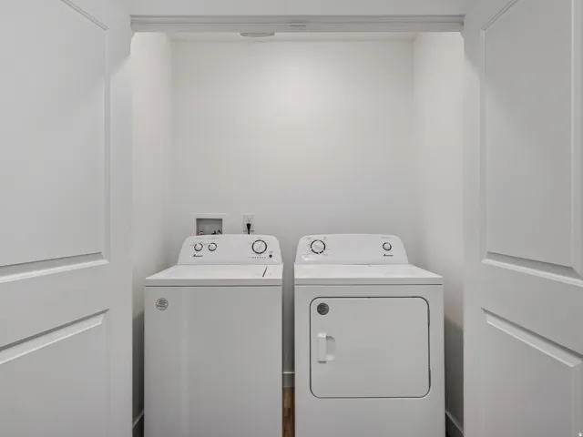 Dedicated laundry alcove with a white washer and dryer set