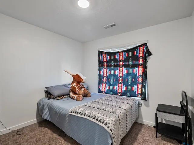 Recessed ceiling light, white walls, window with blinds, carpeted flooring