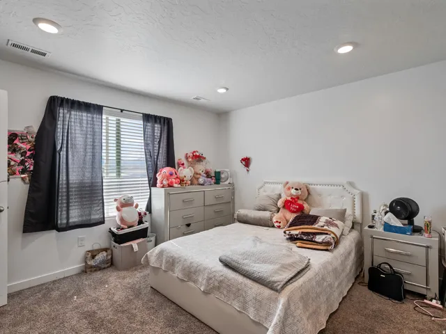 Recessed ceiling lighting, white walls, and a window with blinds