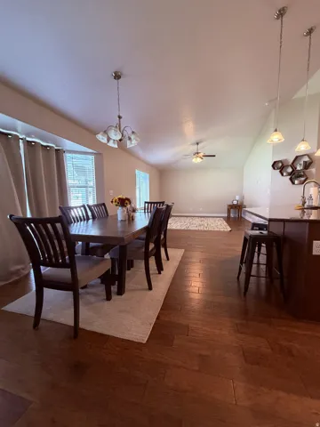 Vaulted ceilings with recessed lighting, wood-finish flooring, bay windows, and a breakfast bar