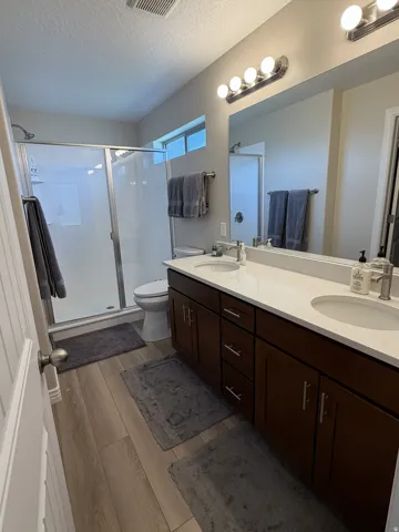 Dual vanity with white countertops and dark wood-finish cabinetry