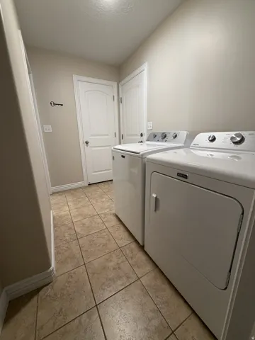 Ceramic tile flooring, two paneled doors with round doorknobs, and a ceiling-mounted light fixture