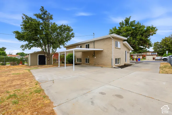 Brick exterior, two-story structure, covered carport, concrete driveway, and detached storage shed
