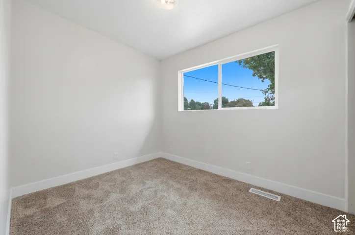 Neutral wall finish, carpeted flooring, and a large window