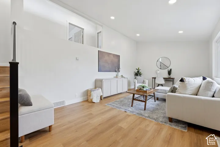 Recessed lighting, wood-finish flooring, and white walls