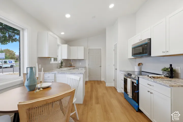 Kitchen featuring white cabinetry, light-toned wood-finish flooring, recessed lighting, a white subway tile backsplash, and light-colored countertops