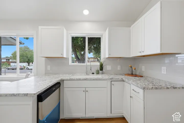 Kitchen featuring white shaker cabinetry, white countertops, a built-in dishwasher, and a white subway tile backsplash