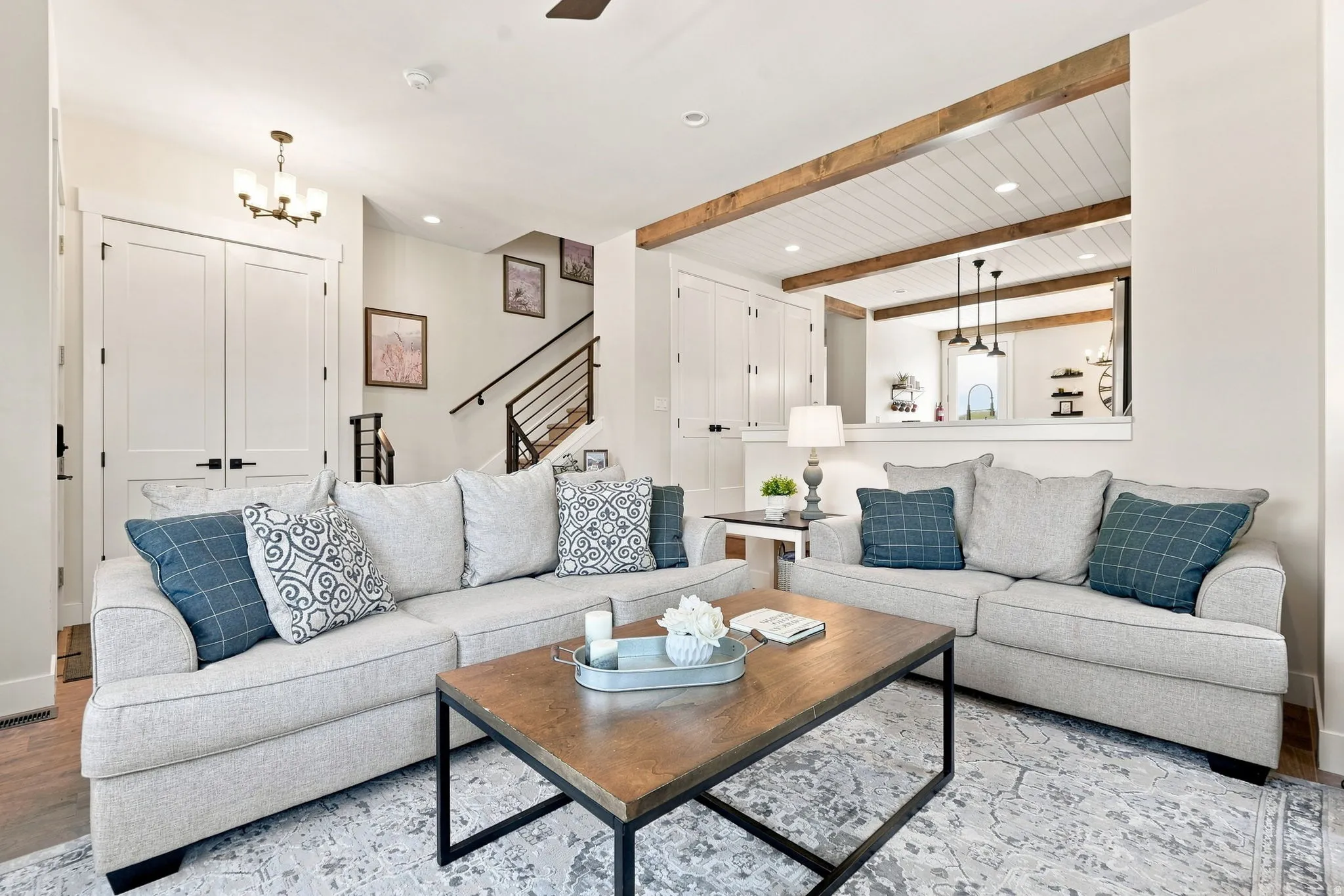 White panel doors, wood beam accents, recessed lighting, and a contemporary staircase with metal railings