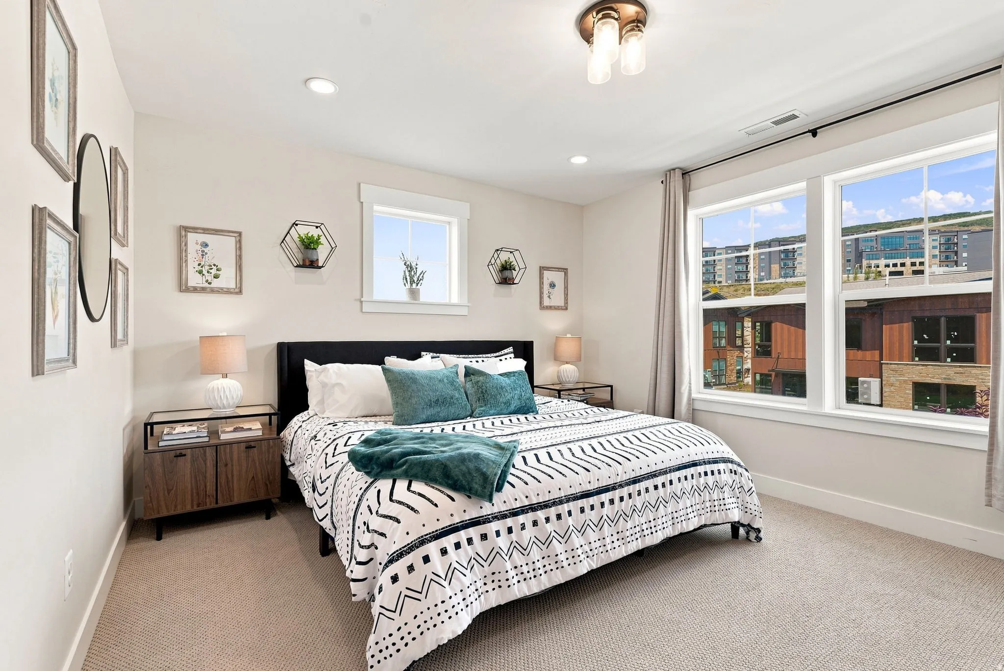 Recessed lighting, large windows, and a ceiling-mounted light fixture illuminate this space, featuring carpet flooring and a built-in window with white trim