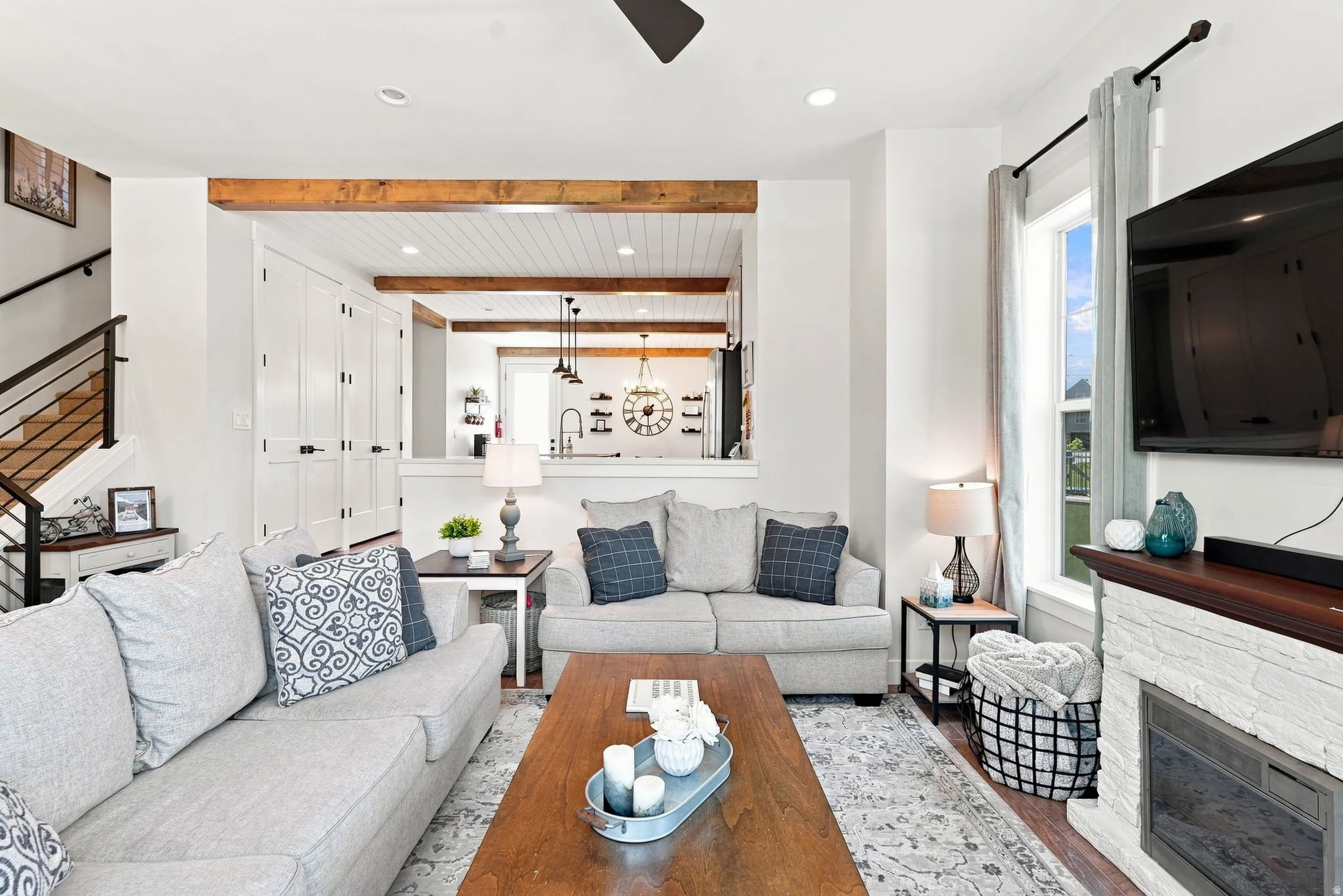 Open-concept living area featuring a fireplace with a wood mantel, recessed lighting, and a partial view of the kitchen