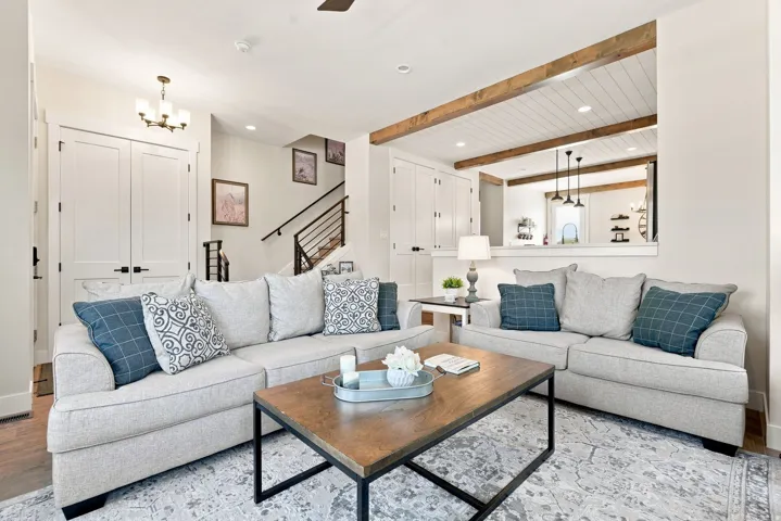 White panel doors, wood beam accents, recessed lighting, and a contemporary staircase with metal railings