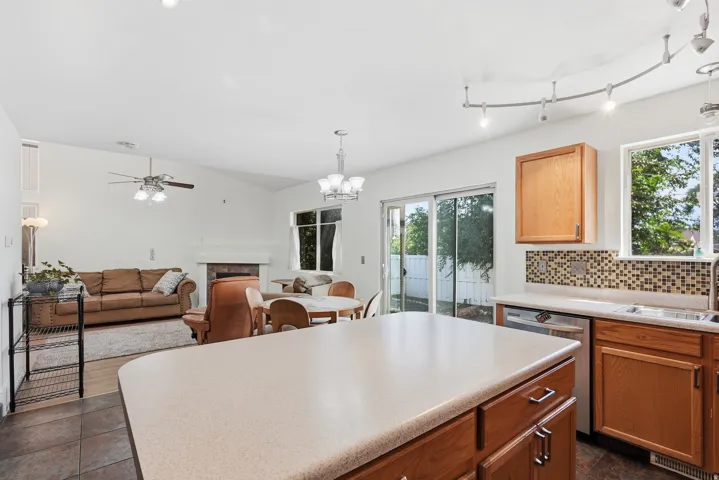 Open-concept living area with vaulted ceilings and a ceiling fan