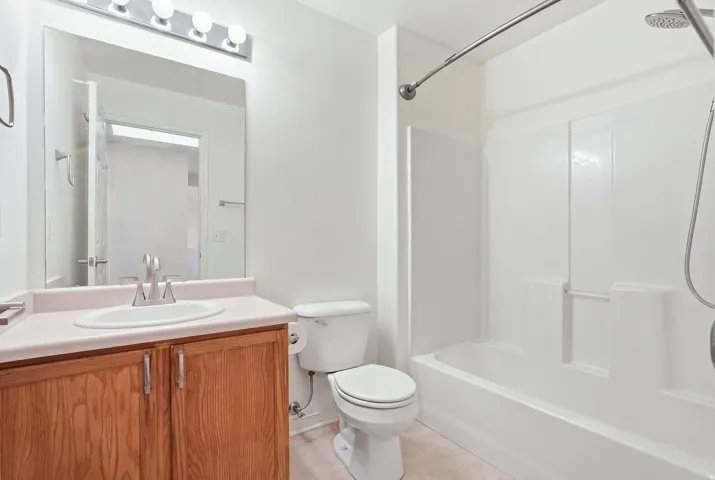 White acrylic tub and shower combination with a curved shower rod