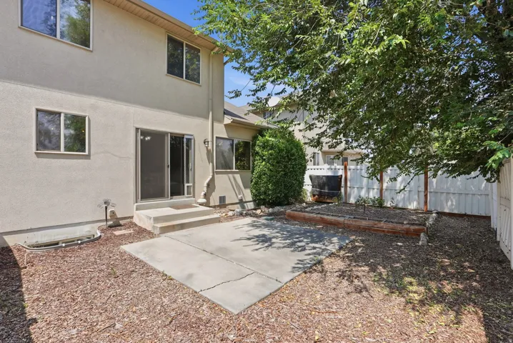 Rear stucco exterior with multiple windows and a sliding glass door