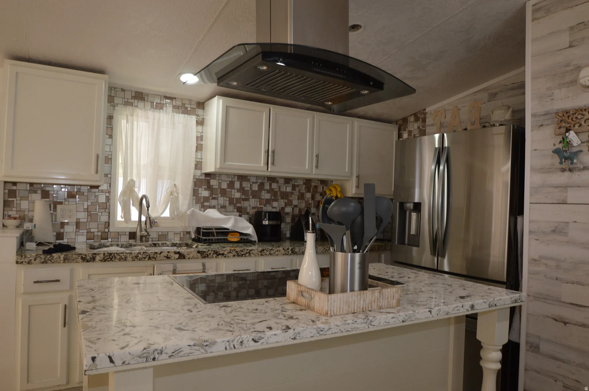 White cabinetry with dark hardware, a mosaic tile backsplash, and a stainless steel French door refrigerator