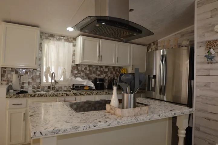 White cabinetry with dark hardware, a mosaic tile backsplash, and a stainless steel French door refrigerator