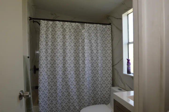 White-tiled shower surround with dark bronze fixtures