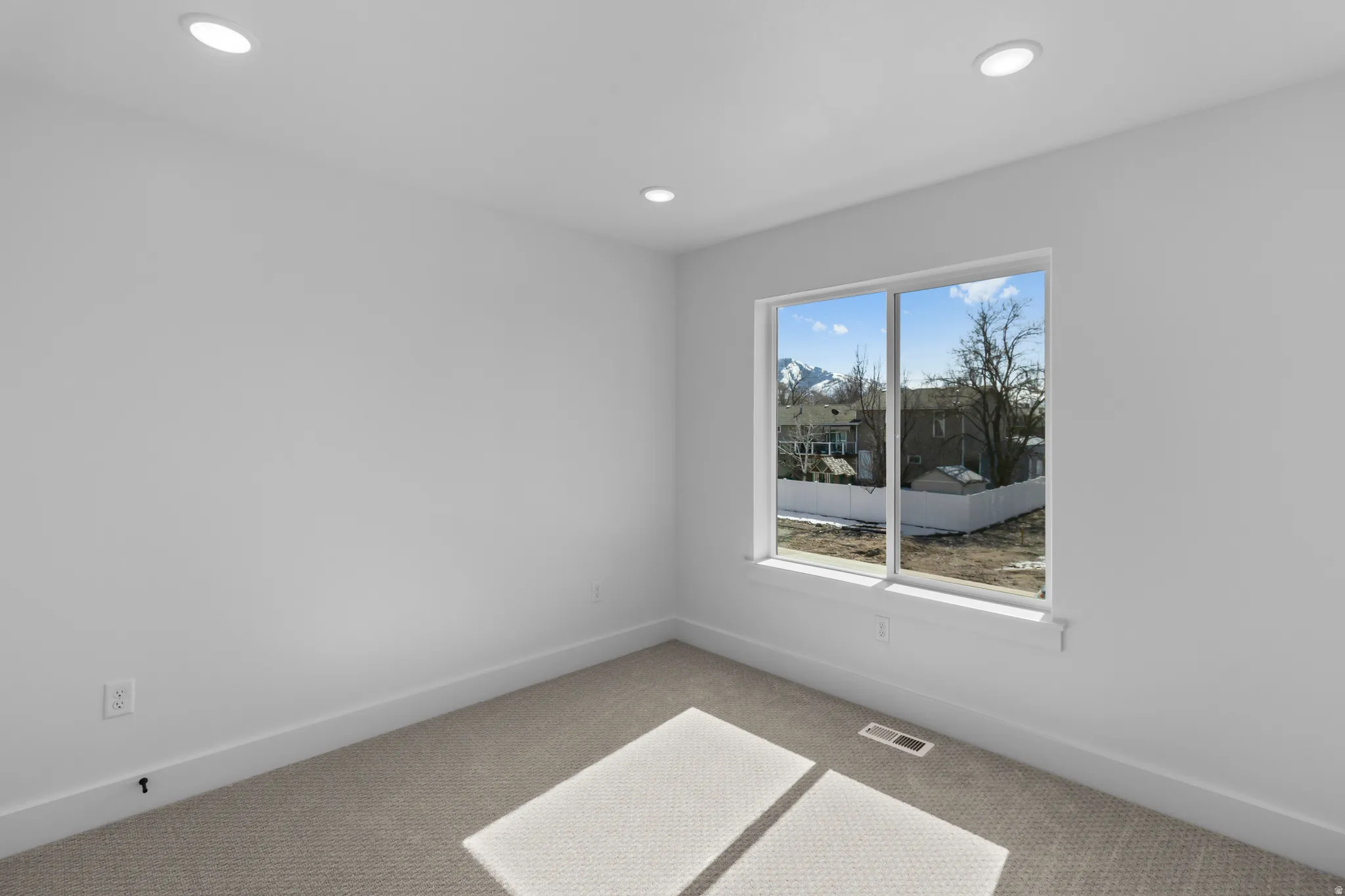Recessed lighting, large window, carpeted flooring, and white trim