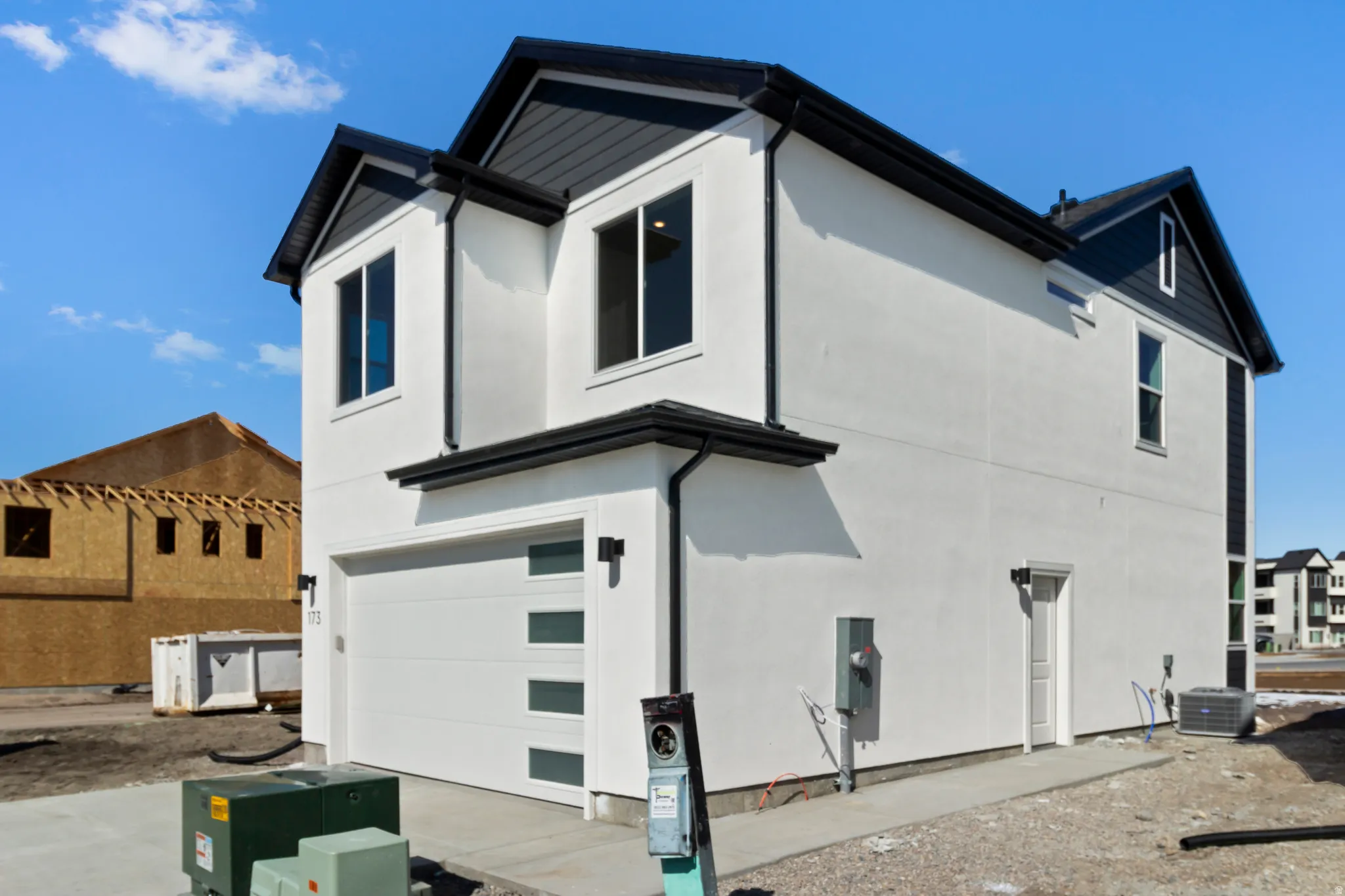 Contemporary exterior with a white finish, dark roof, and accent siding