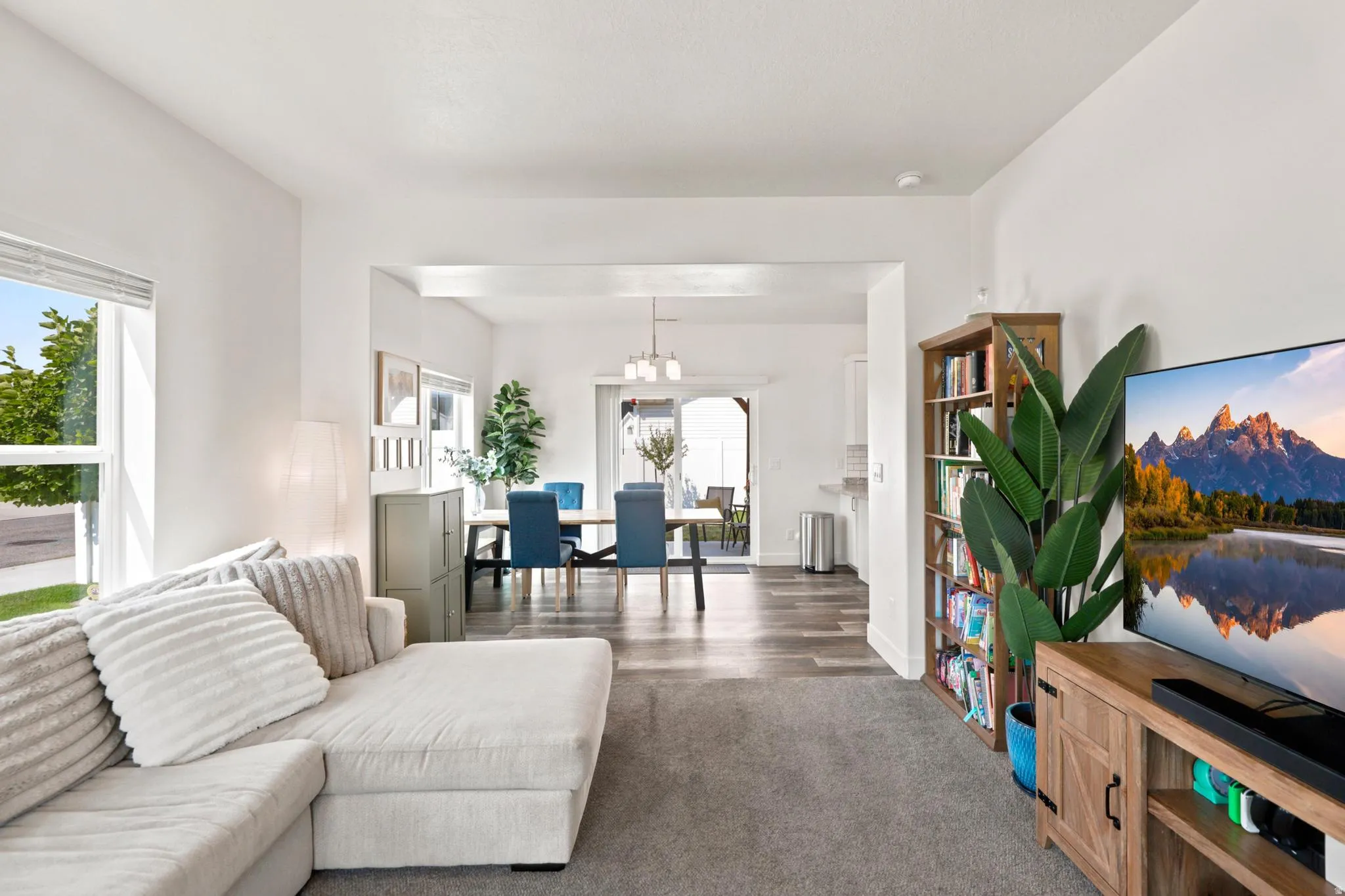 Open-concept living area with light-colored walls and carpet flooring
