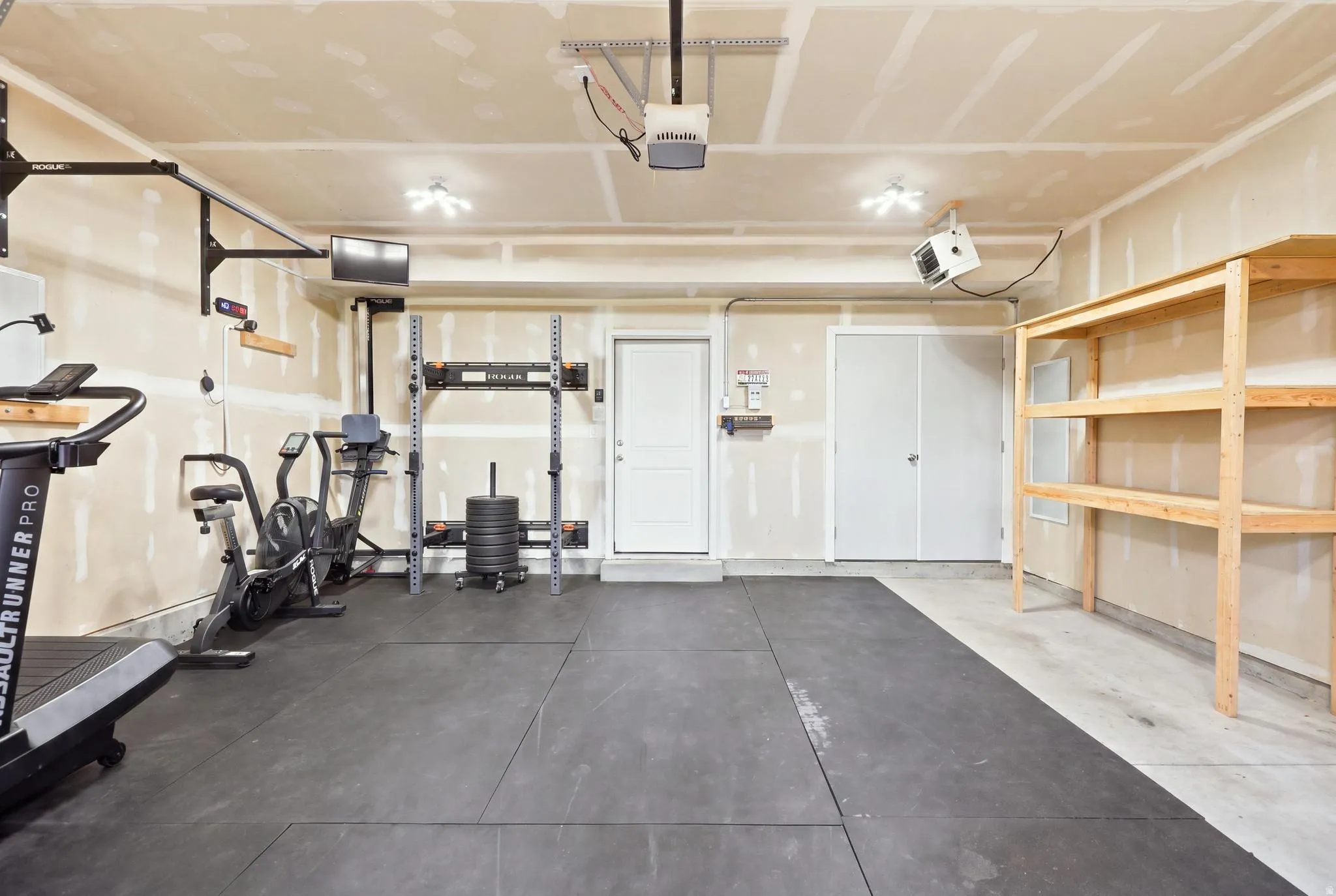 Garage with concrete flooring, overhead lighting, and built-in wooden shelving