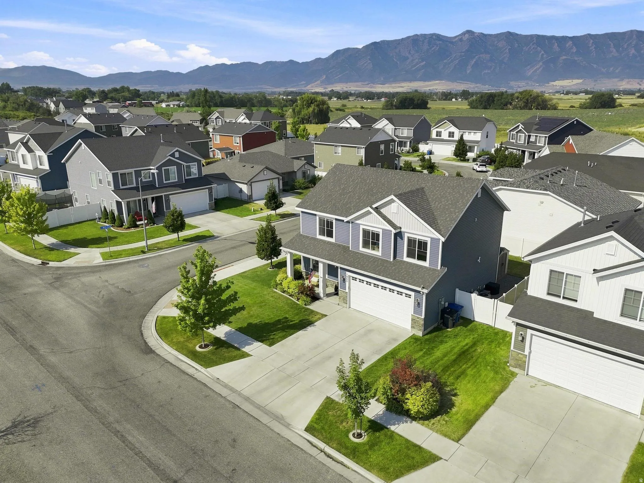 Two-story residence with a two-car garage, front porch, and established landscaping