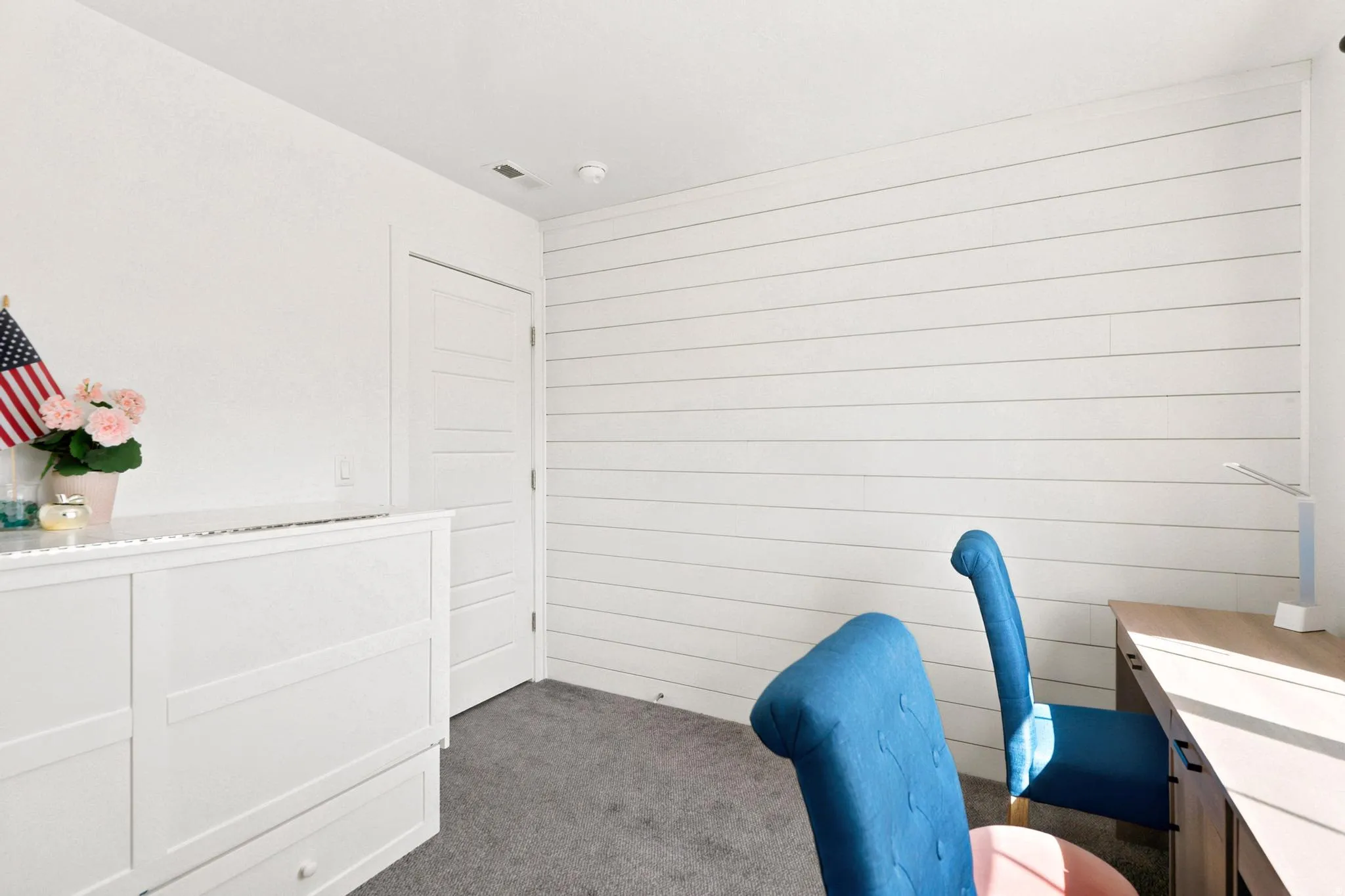 White shiplap accent wall with a flush-mount ceiling light