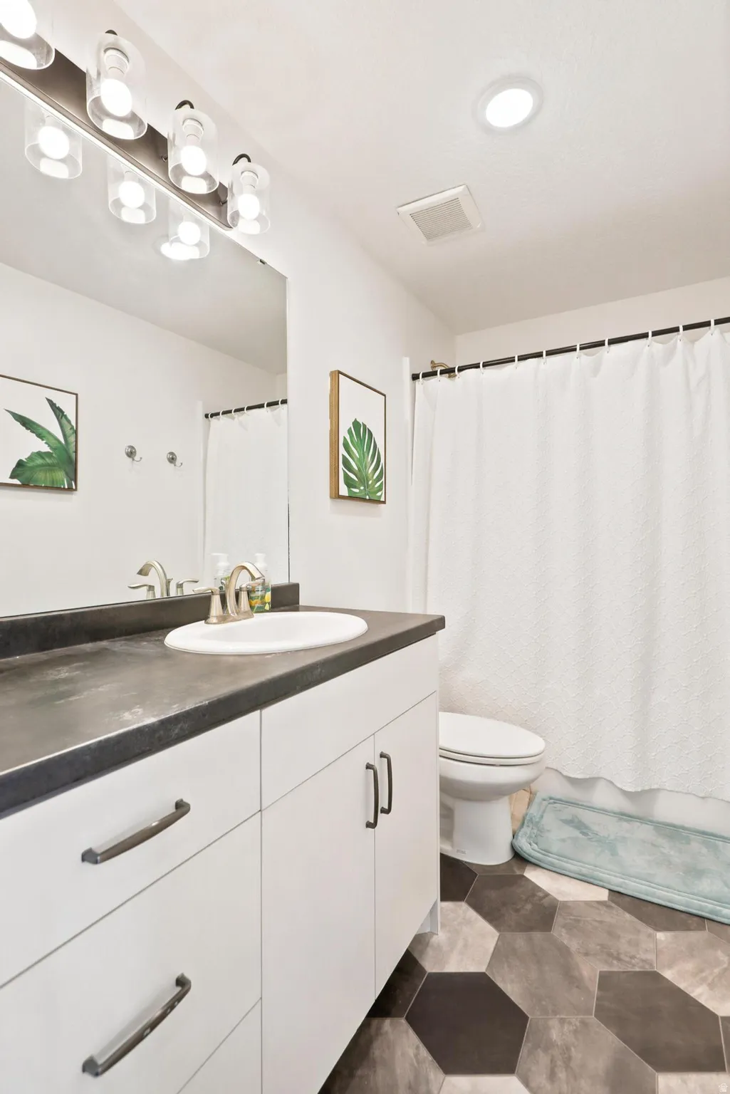 White vanity with dark countertop and undermount sink