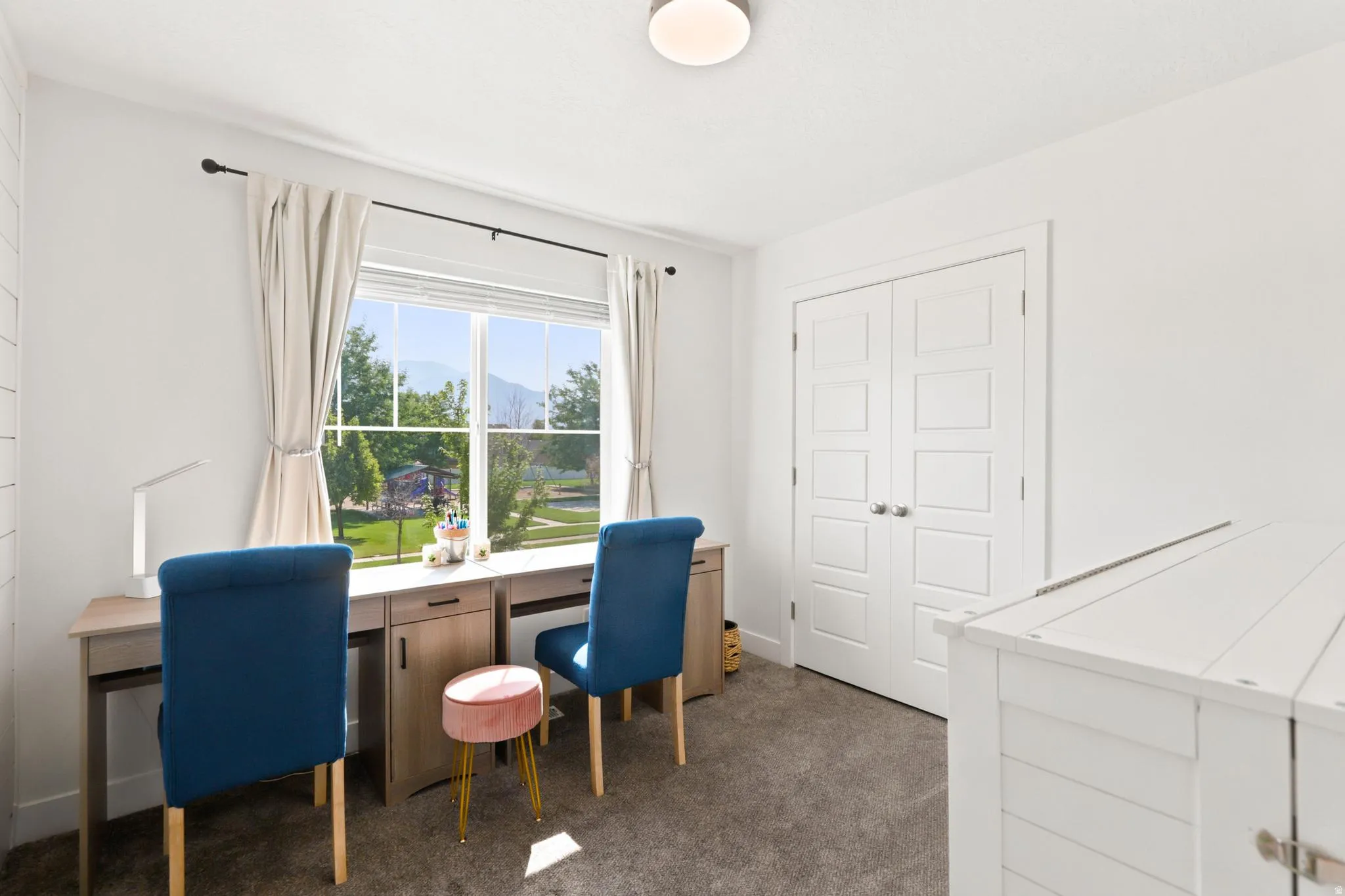 Double French doors, recessed ceiling light, large window, mountain scenery, and durable carpet flooring