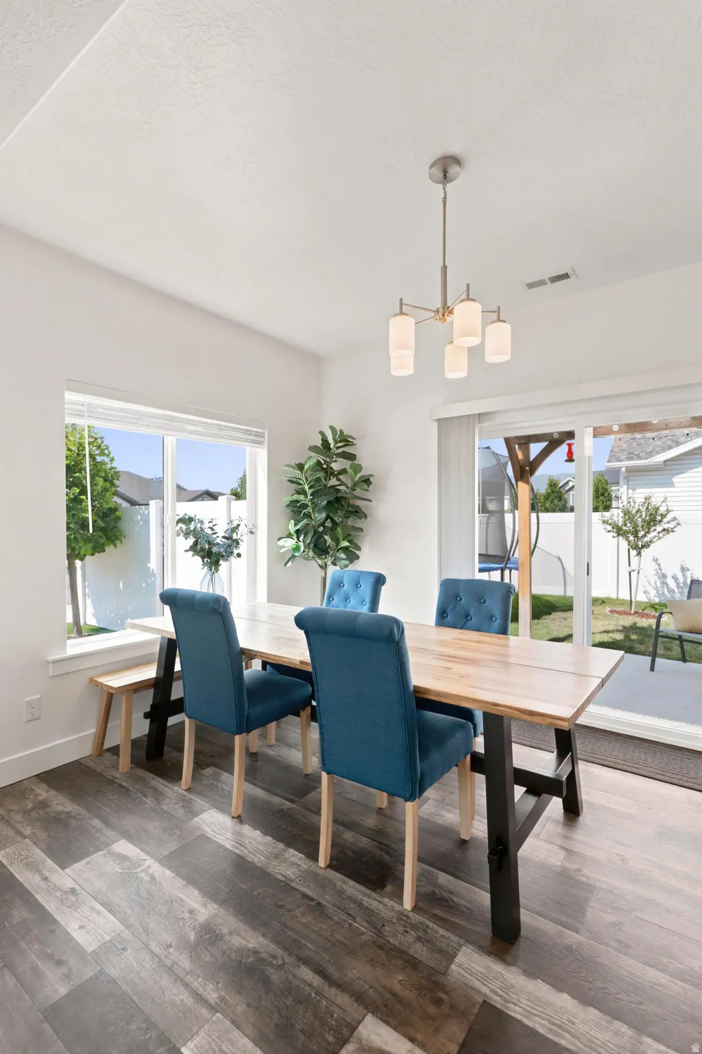 Wood-finish flooring, white walls, large windows, and a sliding glass door to the exterior