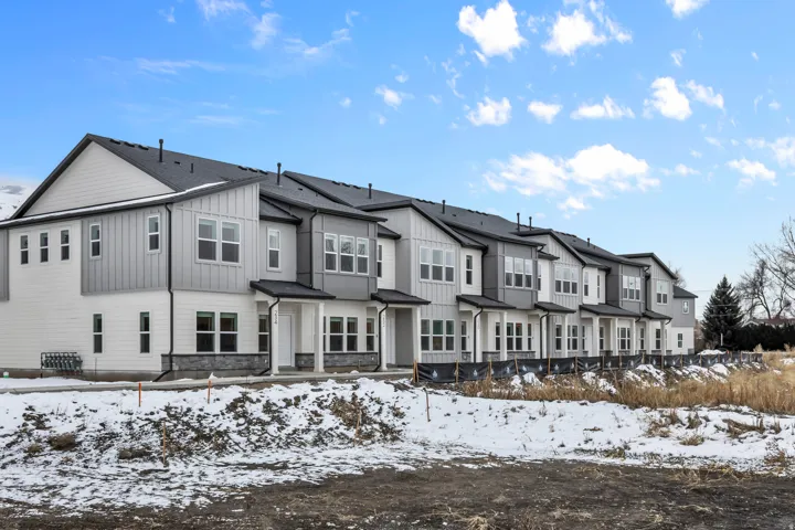 Contemporary multi-story facades featuring white siding, vertical gray paneling, and dark shingle roofs