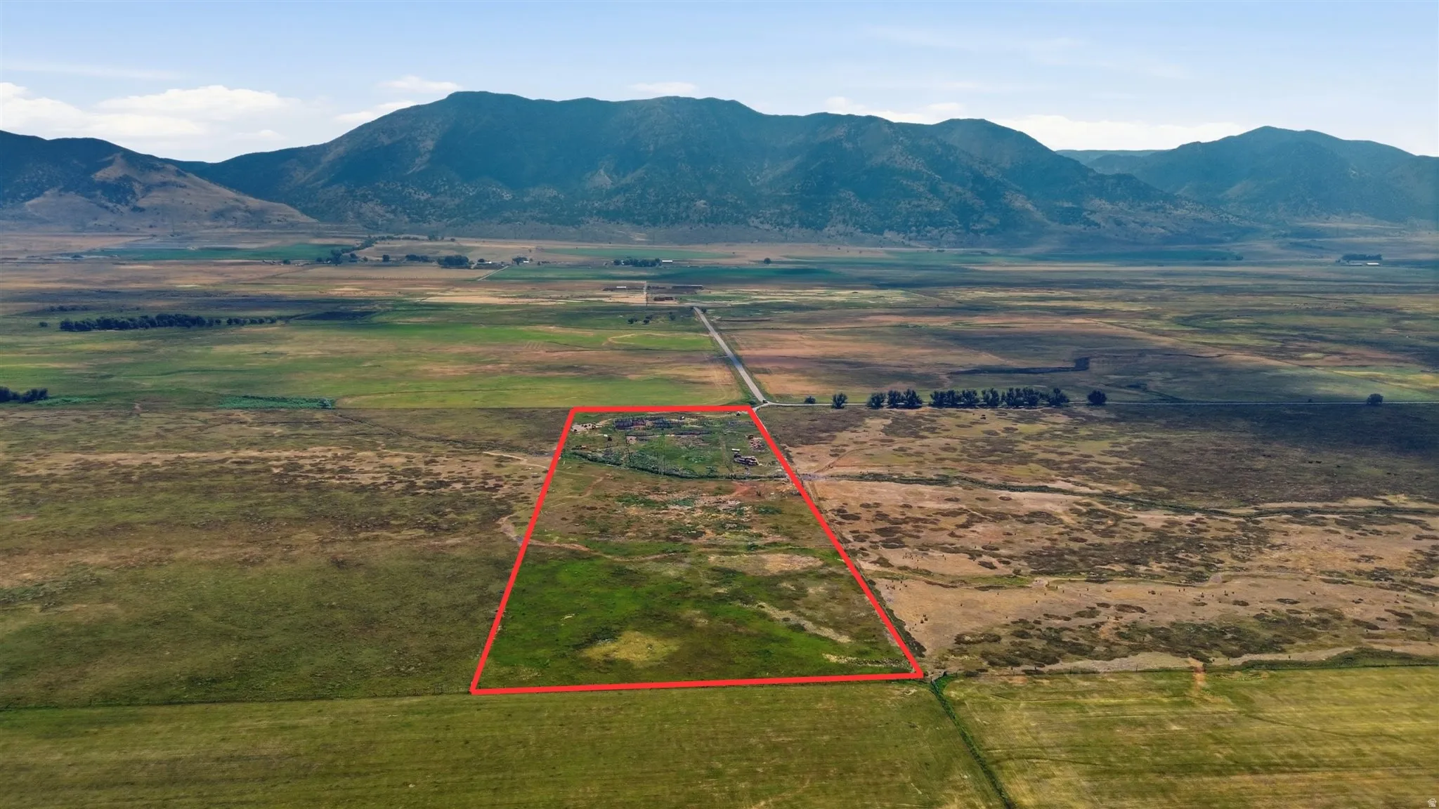 Expansive rural acreage featuring varied terrain and distant mountains