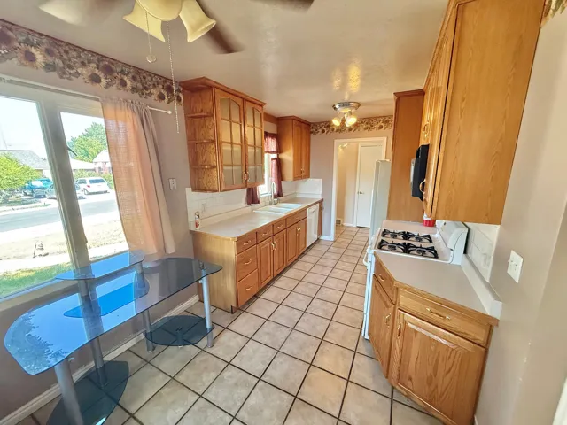 Kitchen featuring wood-finish cabinetry, tile flooring, and white countertops