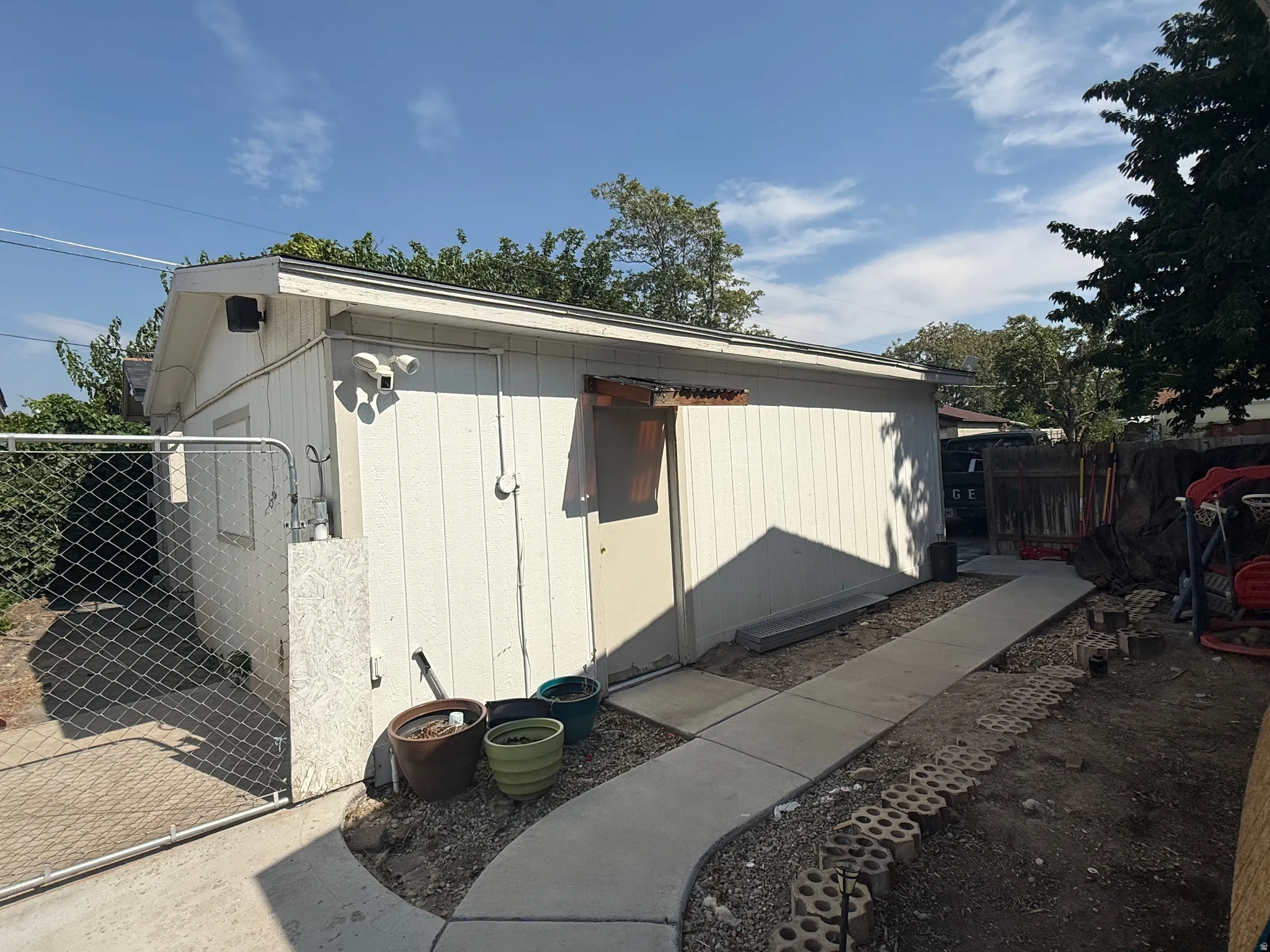 Detached accessory structure with a pitched roof and a concrete pathway