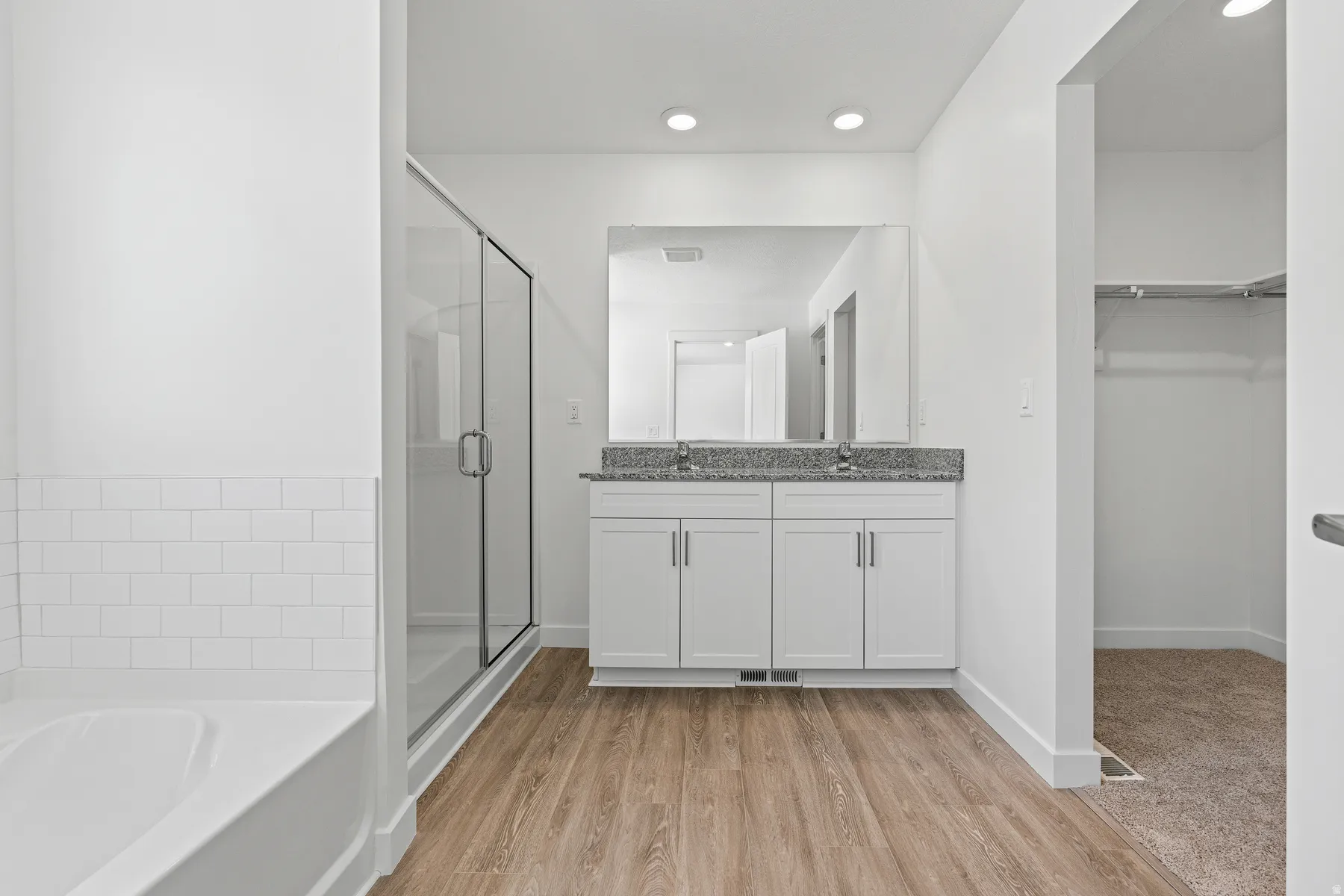 White subway tile accents a soaking tub and glass-enclosed shower