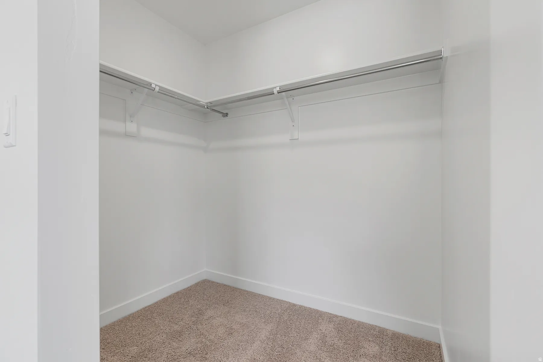 Walk-in closet with carpet flooring and ample hanging space