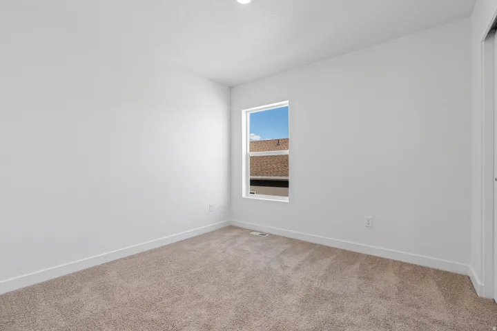 Carpeted flooring, single window, white walls, and a built-in closet