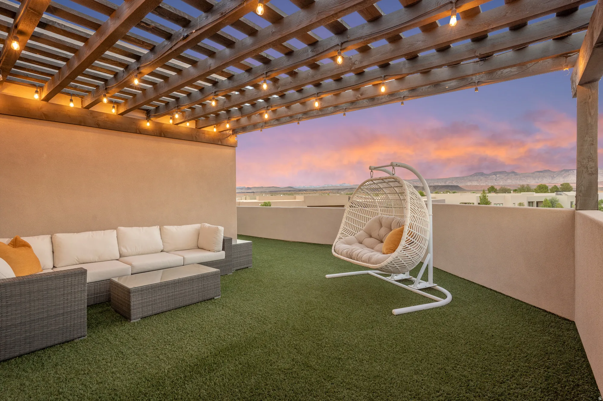 Rooftop deck featuring a wooden pergola, string lighting, and artificial turf flooring